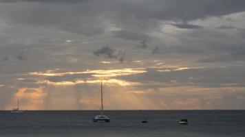 des rayons de le Soleil par spectaculaire foncé des nuages plus de le mer. laps de temps, pittoresque paysage marin. yachts flottant de le côte video