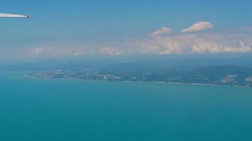 Beautiful picturesque landscape from the window of an airplane. Blue sky, clouds, sea and mountains. Travel concept. video