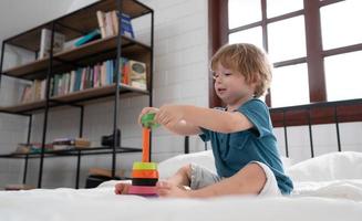 Little boy in his bedroom with a new toy purchased by his parents to help him improve his thinking skills. photo