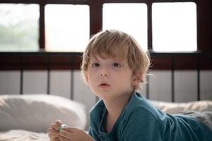 Little boy in his bedroom with a new toy purchased by his parents to help him improve his thinking skills. photo