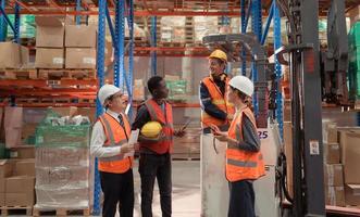 Managers, foremen and warehouse workers Consult together about getting the goods out of the warehouse to finish sending the small merchants tonight. photo