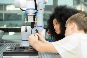 niños utilizando el mano robot tecnología, estudiantes son estudiando tecnología, cuales es uno de el vástago cursos foto