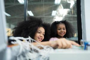 Children using the hand robot technology and having fun Learning the electronic circuit board of hand robot technology, which is one of the STEM courses. photo