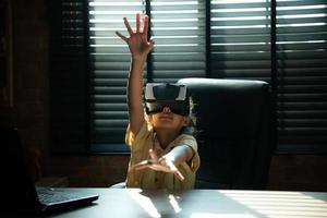 retrato de pequeño niña en oficina habitación de casa con gestos ese son expresado cuando jugando virtual realidad juegos foto