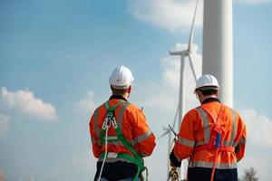 topógrafo y ingeniero examinar el eficiencia de gigantesco viento turbinas ese transformar viento energía dentro eléctrico energía ese es luego usado en diario vida. foto