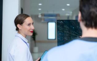 Medical teacher and interns see brain x-ray results of a patient who suffered a concussion after the accident. and inform the patient that the brain is normal photo
