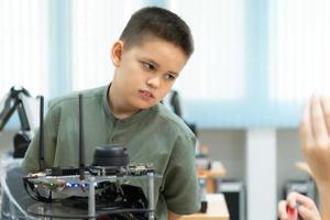 niños utilizando el mano robot tecnología, estudiantes son estudiando tecnología, cuales es uno de el vástago cursos foto