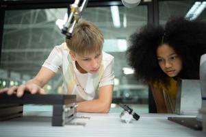 niños utilizando el mano robot tecnología, estudiantes son estudiando tecnología, cuales es uno de el vástago cursos foto