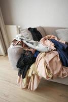 Messy clothes on sofa at home photo