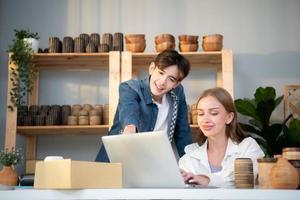 A young couple runs a small business making clay jewelry. They support one another as they work toward becoming larger business in the future. photo