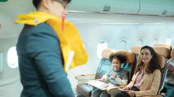 Flight attendants show how to use safety devices and recommend emergency exits. photo