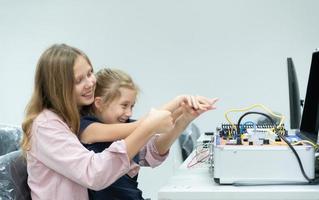 Children using the hand robot technology and having fun Learning the electronic circuit board of hand robot technology, which is one of the STEM courses. photo