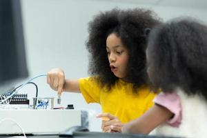 Children using the hand robot technology and having fun Learning the electronic circuit board of hand robot technology, which is one of the STEM courses. photo