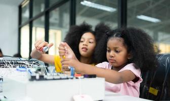 Children using the hand robot technology and having fun Learning the electronic circuit board of hand robot technology, which is one of the STEM courses. photo