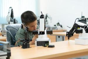 niños utilizando el mano robot tecnología, estudiantes son estudiando tecnología, cuales es uno de el vástago cursos foto