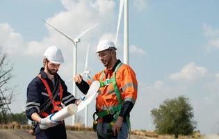 topógrafo y ingeniero examinar el eficiencia de gigantesco viento turbinas ese transformar viento energía dentro eléctrico energía ese es luego usado en diario vida. foto