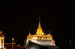 In the dark night, there was still a golden light in the central of Bangkok Thailand, The golden pagoda called the golden mountain temple, Tourist attractions that tourists visit to worship photo