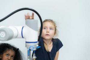 niños utilizando el mano robot tecnología, estudiantes son estudiando tecnología, cuales es uno de el vástago cursos foto