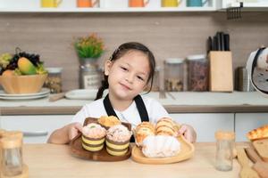 retrato de un pequeño niña en el cocina de un casa teniendo divertido jugando horneando un pan foto