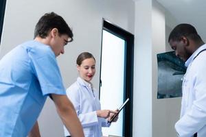 Medical teacher and interns see brain x-ray results of a patient who suffered a concussion after the accident. and inform the patient that the brain is normal photo
