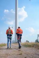 Surveyor and engineer Examine the efficiency of gigantic wind turbines that transform wind energy into electrical energy that is then used in daily life. photo