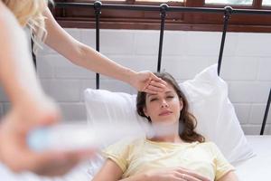 LGBT Young couple taking care of each other in times of illness, Checking your temperature to ensure that are not seriously ill. photo