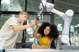 niños utilizando el mano robot tecnología, estudiantes son estudiando tecnología, cuales es uno de el vástago cursos foto