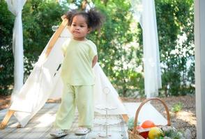 un brillante y linda pequeño niña con divertido jugando en el jardín de el casa. foto