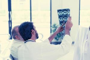 The doctor talks to the patient's parents about the results of the X-ray of the brain. that has been affected by an accident, Which the results of the examination came out good photo