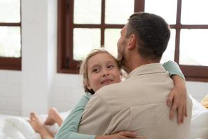 A little girl expresses his feelings for his father. By embracing as soon as you wake up in the beginning of the day photo