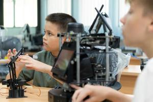 niños utilizando el mano robot tecnología, estudiantes son estudiando tecnología, cuales es uno de el vástago cursos foto