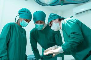 Medical lecturer in cardiology and medical team in the heart transplantation room A knife is being used for surgery on a patient. photo