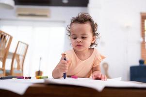 un pequeño niño imaginación es representado mediante de colores lápiz dibujos, con el madre atentamente supervisando en el vivo habitación de el casa. foto