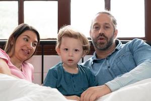 After the little boy wakes up from his nap, his father and mother engage in enjoyable activities in his bedroom. photo