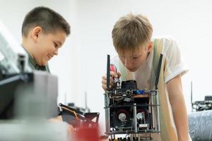 niños utilizando el mano robot tecnología, estudiantes son estudiando tecnología, cuales es uno de el vástago cursos foto