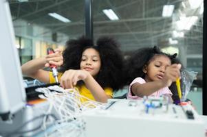 Children using the hand robot technology and having fun Learning the electronic circuit board of hand robot technology, which is one of the STEM courses. photo