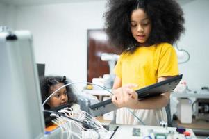 jovenes utilizando el mano robot tecnología son teniendo divertido aprendizaje el electrónico circuito tablero de mano robot tecnología, cuales es uno de el vástago cursos foto