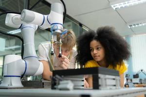 niños utilizando el mano robot tecnología, estudiantes son estudiando tecnología, cuales es uno de el vástago cursos foto