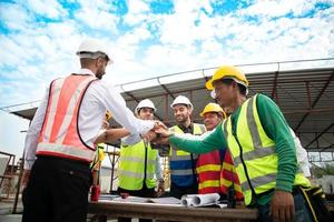Construction engineers, architects, and foremen form a group. Participate in a meeting to plan new construction projects. Cheers to express happiness that the event was successfully accomplished. photo