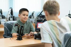 niños utilizando el mano robot tecnología, estudiantes son estudiando tecnología, cuales es uno de el vástago cursos foto