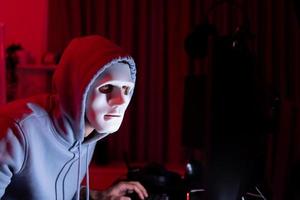 This is the face of a hacker who is knowledgeable with operating systems and other programs. He will exploit flaws and breach the computer system to cause damage. photo