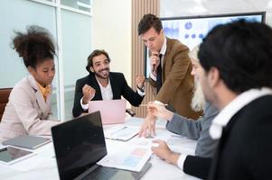 In the meeting room of an international business corporation, a diverse group of young entrepreneurs are enthusiastically taking their ideas and sharing perspectives. photo