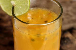 Closeup glass of passionfruit, maracuya juice. Healthy drinks concept photo