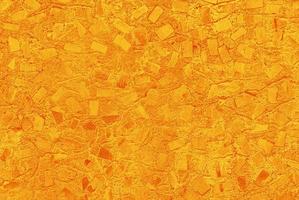 yellow-orange abstract texture of concrete painted wall with random mosaic pattern photo