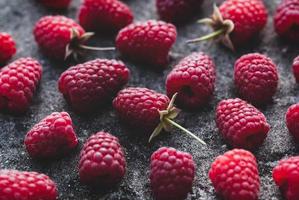 Raspberries food background - ripe harvested raspberry arranged on gray stone texture photo
