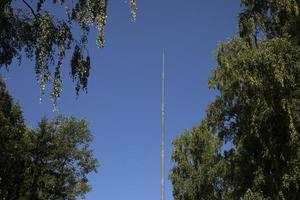 Antenna in park. Communication tower without equipment. High steel pillar. photo