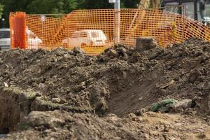 Excavated soil at construction site. Laying pipes in city. Excavated earth. Cable trench. photo