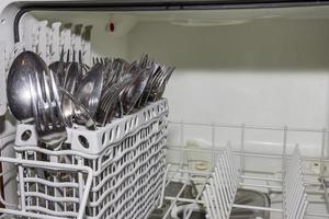 knives and forks ready to be washed in a dishwasher photo