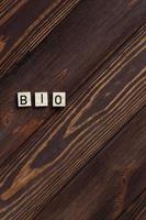 Bio word label lettering on wooden background, copy space photo