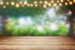 Empty wooden table with party in garden background blurred photo